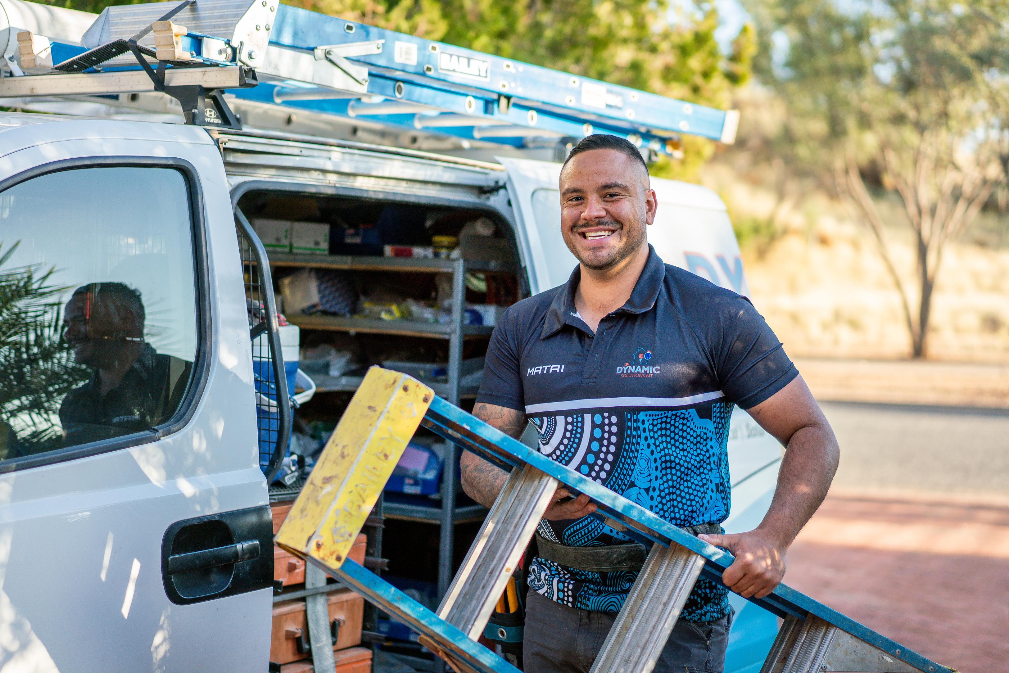 Man taking a ladder from a van