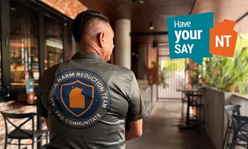  Person in an Alcohol Harm Reduction Team shirt with a 'Have Your Say NT' graphic.