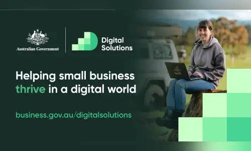 Australian Government Digital Solutions banner promoting support for small businesses to thrive in a digital world, featuring a person using a laptop outdoors and the website business.gov.au/digitalsolutions.